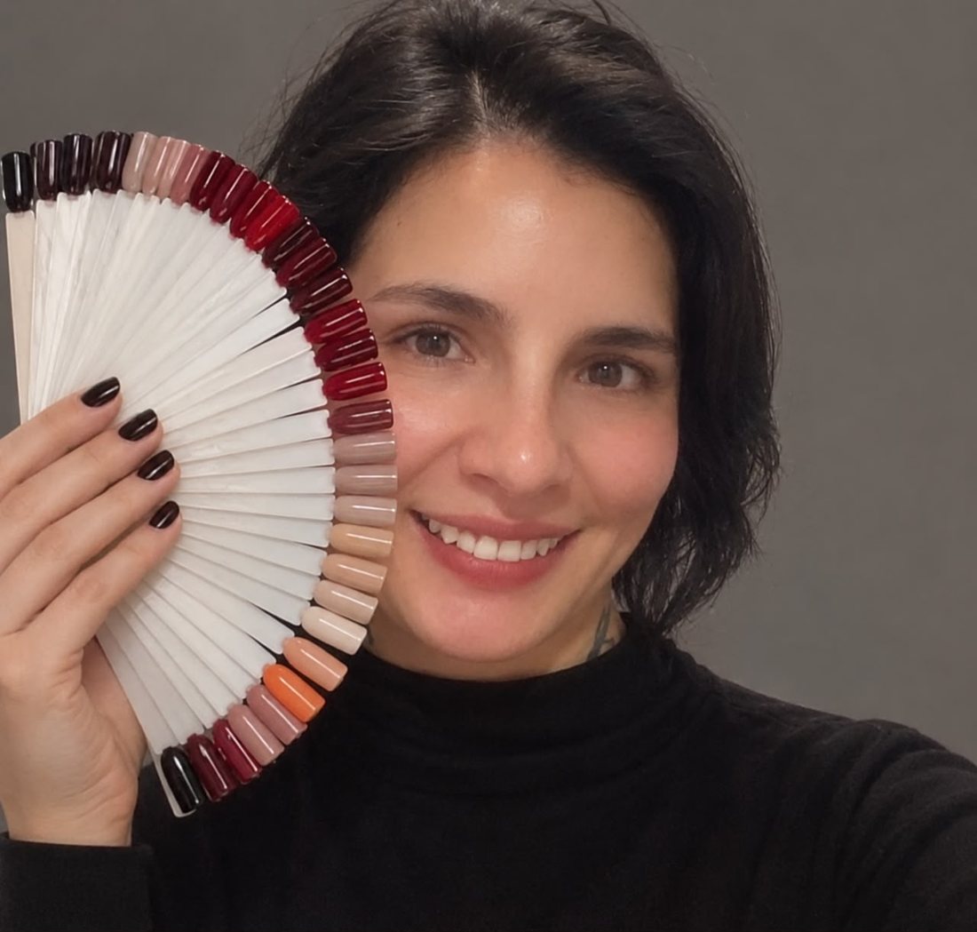 Malú sonriendo con un muestrario de colores en abanico